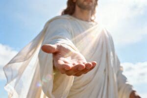 Jesus stands with an open hand extended toward viewers. Bright sunlight shines behind him, creating a warm glow in the background. The scene conveys a message of invitation and hope for believers.